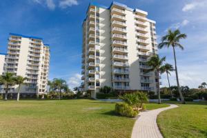 un gran edificio de apartamentos con palmeras y una pasarela en Wandas Estero Beach Tennis C707- wkly New, en Fort Myers Beach