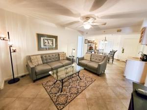 a living room with two couches and a table at Freds Santa Maria Harbour Resort Condo in Fort Myers Beach