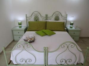 a bedroom with a white bed with green pillows at Villa Margherita Suite & charme in Pula