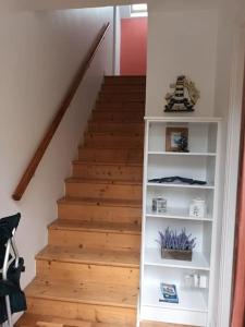 a staircase with a white book shelf next to a stair case at Village centre apartment in Lahinch