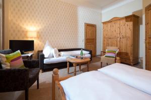 a hotel room with a bed and a couch at Logierhaus am Denkmal in Norderney