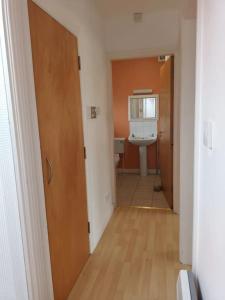 a hallway of a bathroom with a sink and a toilet at Village centre apartment in Lahinch