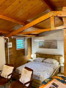 - une chambre avec un lit et deux chaises dans l'établissement Les îlots du soleil levant, à Saint-André