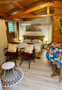 a bedroom with two beds and a table and chairs at Les îlots du soleil levant in Saint-André
