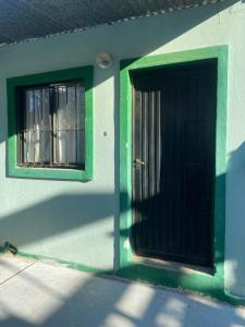 un edificio verde y blanco con una puerta y dos ventanas en Mono ambiente en Corrientes Capital en Corrientes