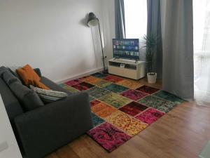 a living room with a couch and a rug at White City Apartment, your London stay in London