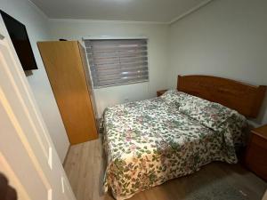 niewielka sypialnia z łóżkiem i oknem w obiekcie Casa 3 dormitorios Coquimbo w mieście Coquimbo