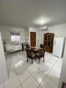 a kitchen with a table and chairs and a refrigerator at Condomínio Serra da Saudade in Piçarras