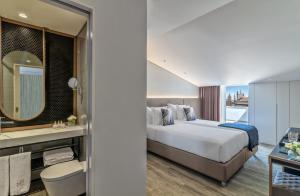 Hotel Moon & Sun Braga في براغا: غرفه فندقيه بسرير وحمام