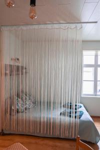 a bedroom with a bed covered in curtains at Kantreküla Apartment in Viljandi