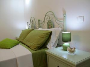 1 dormitorio con 1 cama y 1 mesa con lámpara en Villa Margherita Suite & charme, en Pula