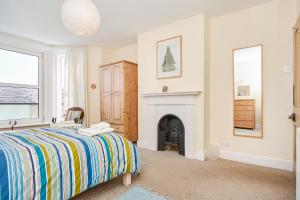 a bedroom with a bed and a fireplace at The Salt Pot in Ventnor