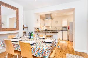 a dining room with a table and chairs and a kitchen at The Salt Pot in Ventnor