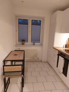 eine kleine Küche mit einem Tisch und einem Fenster in der Unterkunft Hyggelige und zentrale Eigentumswohnung in Rostock
