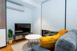 a living room with a couch and a tv at Relaxing Urban Oasis in Melbourne