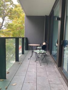 a patio with a table and a chair on a balcony at Relaxing Urban Oasis in Melbourne