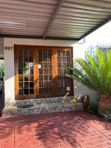 una puerta delantera de una casa con una palmera en Christa's Place 897 en Pretoria