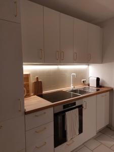 a kitchen with white cabinets and a sink at Hyggelige und zentrale Eigentumswohnung in Rostock