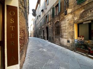 eine leere Straße in einer Gasse zwischen zwei Gebäuden in der Unterkunft LA CASINA IN VIA FRANCIOSA in Siena