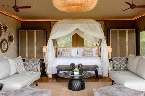 馬賽馬拉的住宿－JW Marriott Masai Mara Lodge，一间卧室配有一张床、两把椅子和一张桌子