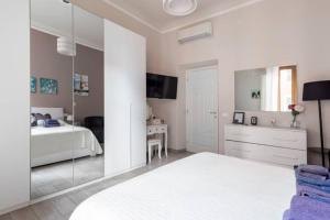 biała sypialnia z łóżkiem i lustrem w obiekcie Big Central Room w mieście La Spezia