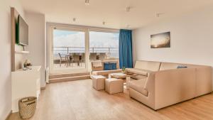 a living room with a couch and a table at Holiday Suites Blankenberge in Blankenberge
