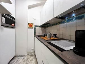 eine Küche mit weißen Schränken und einer Arbeitsplatte in der Unterkunft LA CASINA IN VIA FRANCIOSA in Siena