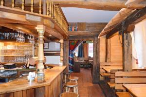 a bar in a restaurant with wooden walls and stools at Hotel "Cafe Verkehrt" - Wellcome Motorbiker, Berufsleute und Reisende im Schwarzwald in Oberhof