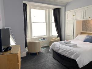 a hotel room with a bed and a television at Marine View Guest House in Scarborough