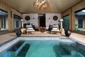 馬賽馬拉的住宿－JW Marriott Masai Mara Lodge，客厅设有大型游泳池,拥有天花板