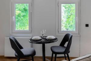 a black table with two chairs and two windows at Lovely & Cozy Studio at Beyoglu in Istanbul