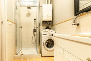 a bathroom with a washing machine and a sink at HouSmart Capo di Lucca 1 in Bologna