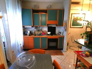 eine Küche mit grünen und orangefarbenen Schränken und einem Tisch in der Unterkunft Peppe's House in San Vito Chietino