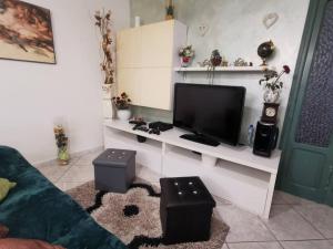 sala de estar con TV en un estante blanco en Peppe's House, en San Vito Chietino