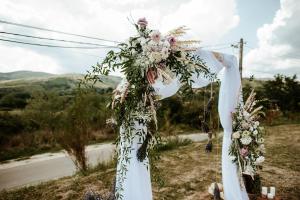 a wedding arch with flowers on a road at Pensiunea La Popa’s ( Vulcanii Noroioși ) 