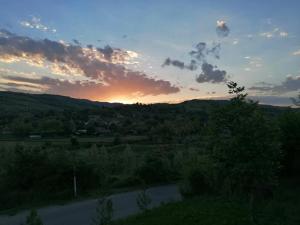 einen Sonnenuntergang über einem Feld mit einer Straße in der Unterkunft Pensiunea La Popa’s ( Vulcanii Noroioși ) 