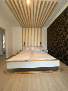 a bedroom with a large bed with a wooden ceiling at Pensiunea La Popa’s ( Vulcanii Noroioși ) 