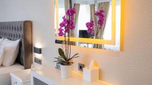 a bedroom with a table with a mirror and flowers at Loop Hotel Bosphorus İstanbul in Istanbul