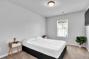 um quarto branco com uma cama grande e uma janela em The GoodLiving Experience (Entire Town House) em Atlanta