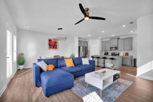 uma sala de estar com um sofá azul e uma ventoinha de tecto em The GoodLiving Experience (Entire Town House) em Atlanta