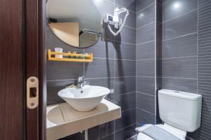 La salle de bains est pourvue d'un lavabo, de toilettes et d'un miroir. dans l'établissement Naias, à Neos Marmaras