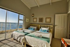 a bedroom with two beds with a view of the ocean at Atlantic Waterfront Cottage D3, 3 bedroom sea view in Swakopmund