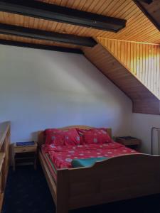 a bedroom with a bed with red sheets and a staircase at Zlatiborski Kutak in Zlatibor