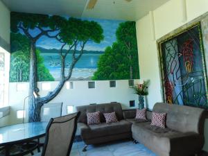 d'un salon avec une table et une peinture murale. dans l'établissement Cabinas Jimenez, à Puerto Jiménez