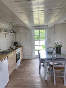 a kitchen with a table and a table and chairs at Flickebäck in Förslöv