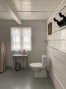 ein Bad mit einem WC, einem Tisch und einem Fenster in der Unterkunft Flickebäck in Förslöv