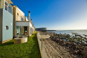 a building on the beach next to the ocean at Atlantic Waterfront Cottage D3, 3 bedroom sea view in Swakopmund