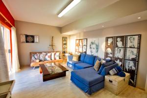 een woonkamer met een blauwe bank en een tafel bij Atlantic Waterfront Cottage D3, 3 bedroom sea view in Swakopmund