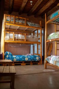 a room with two bunk beds and a table at KONDUR ELEMENTOS ECO HOSTEL in Las Compuertas