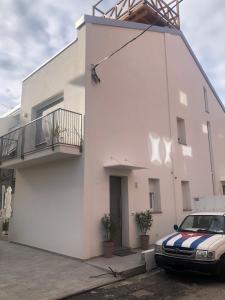 a white building with a car parked in front of it at Residence TRE LEONI in Caorle